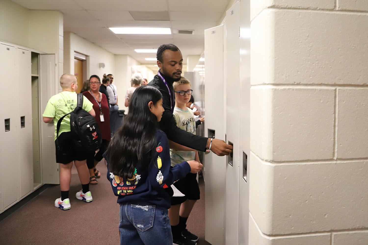 Barr teacher helping 6th Graders open their lockers.